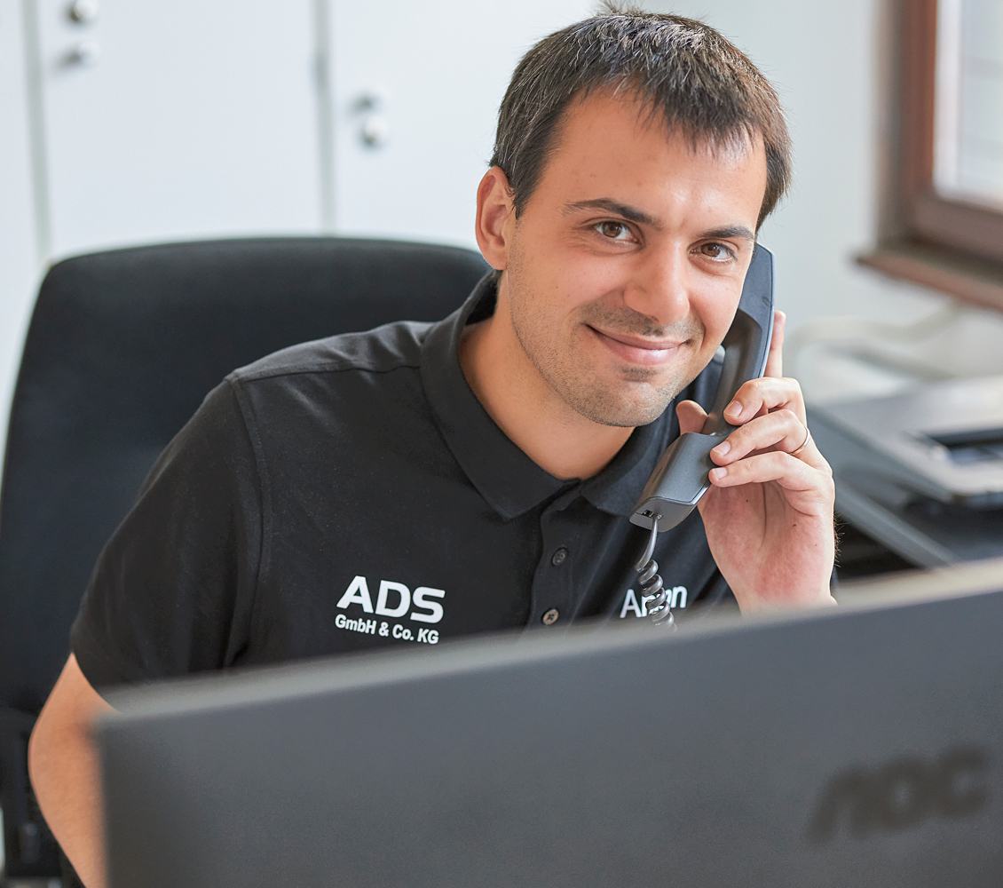 ADS freundlicher Kundendienstmitarbeiter am Telefon, der professionellen Service bietet.